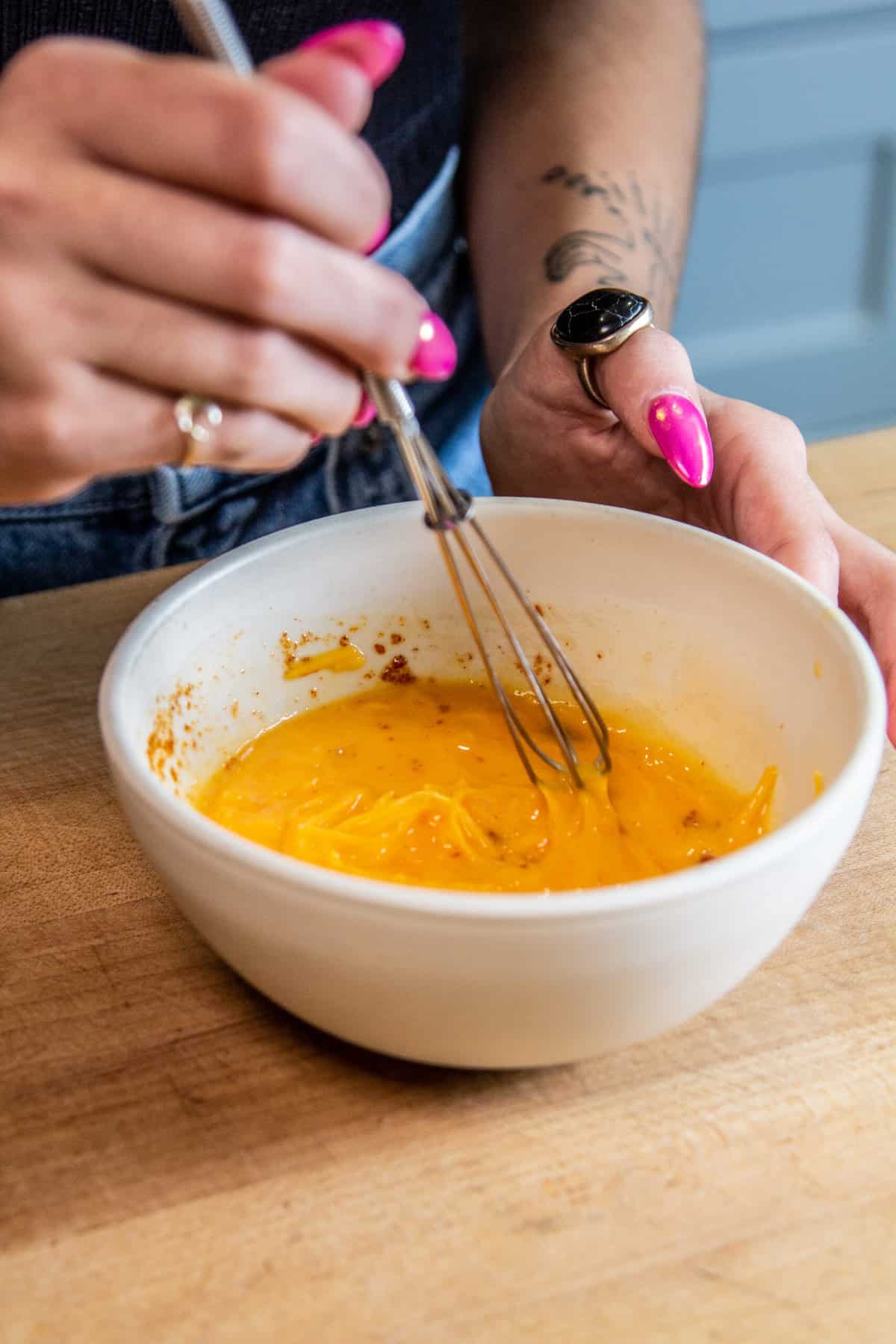 hand whisking eggs & cheese