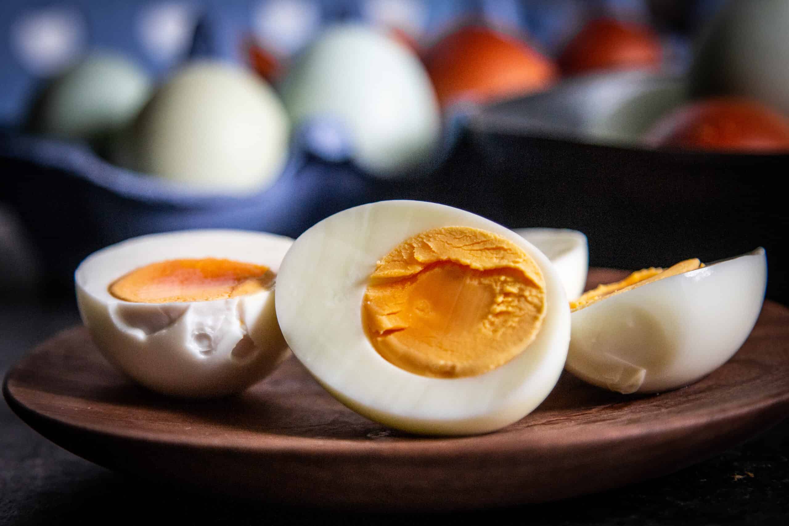 Hard-boiled eggs cut in half on a wooden plate