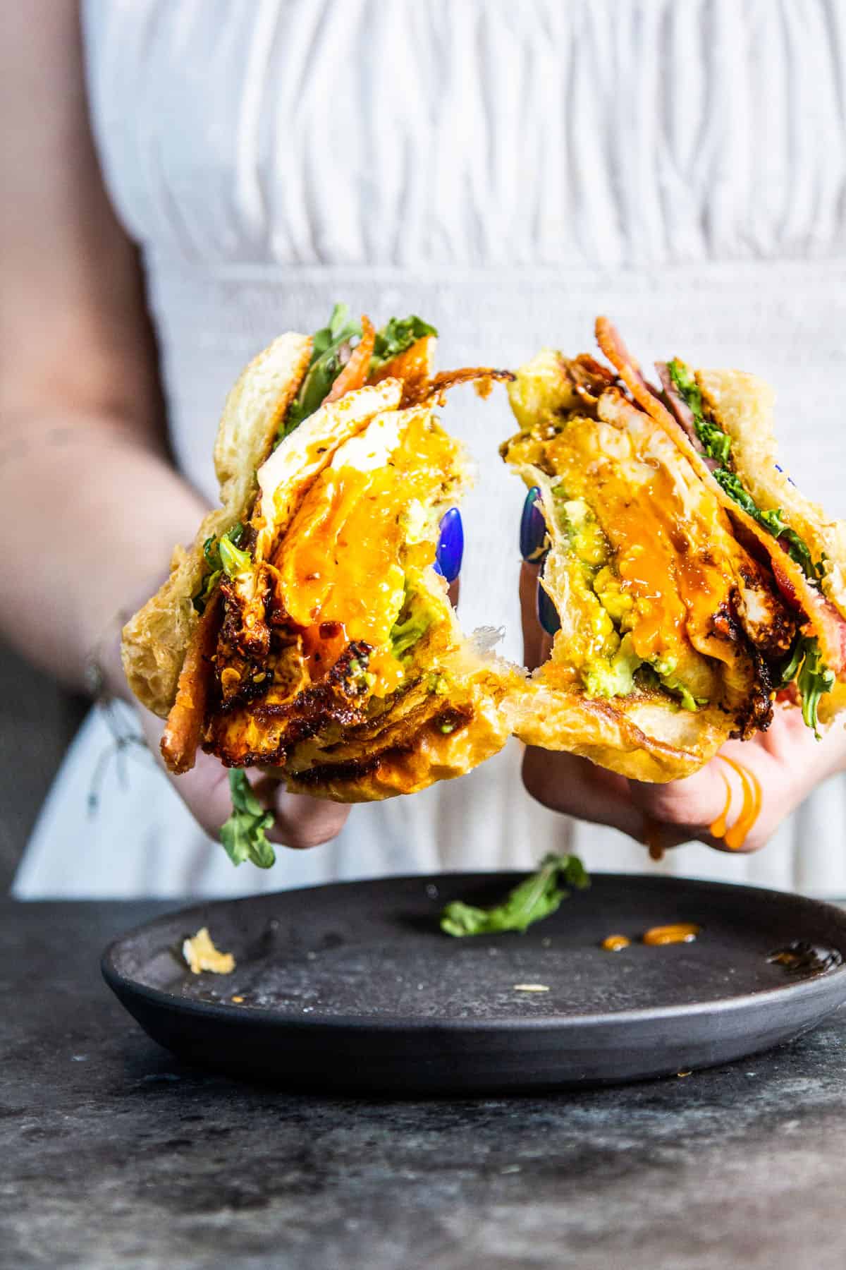 hand holding sandwich cut in half