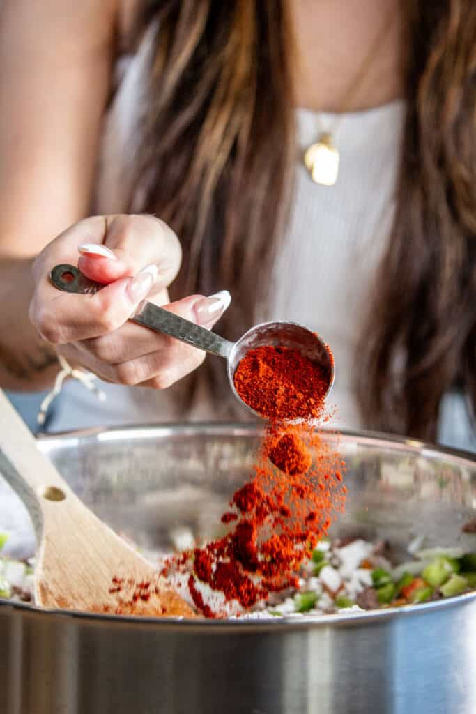 seasoning meat & veggies with red paprika