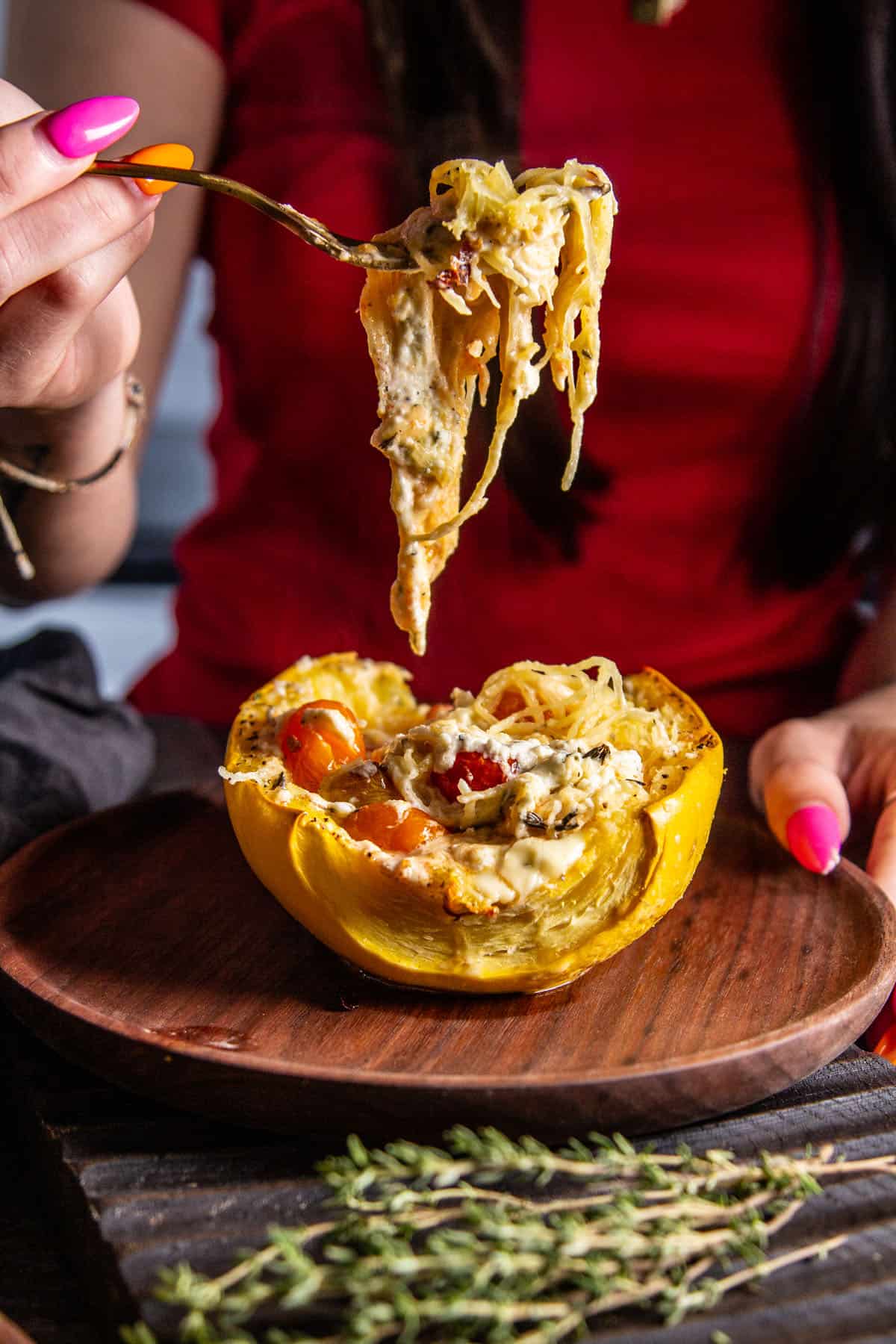 hand holding spaghetti squash on a fork over the squash