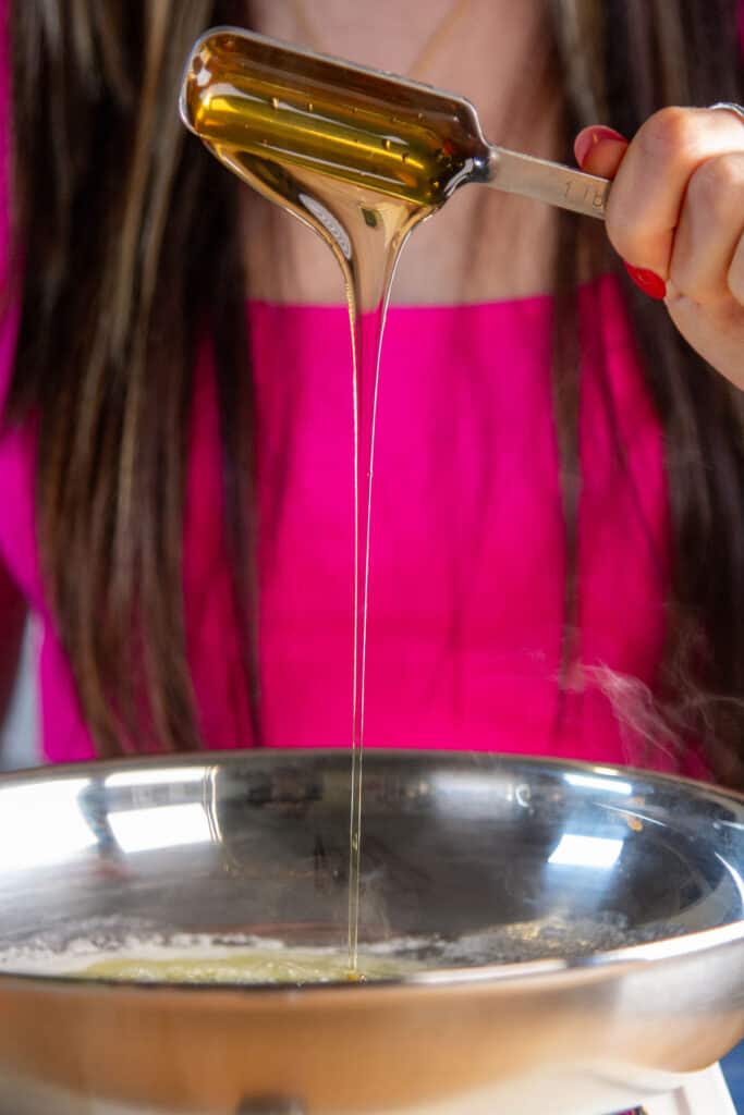 measuring honey into skillet with butter